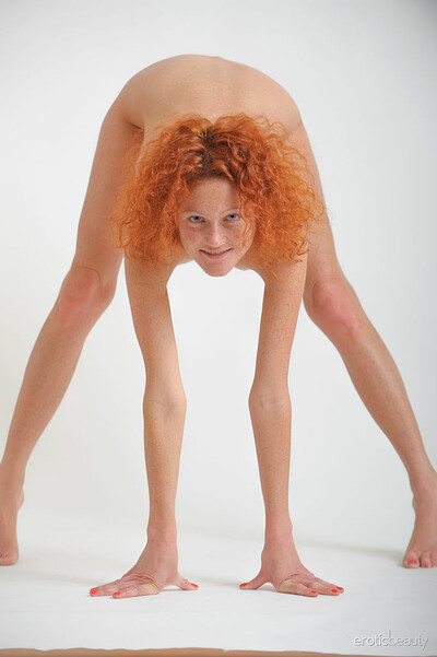 Petite redhead Natalie Red displays her perky body