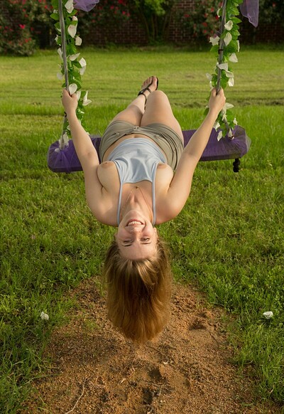 Natlie Austin bends over the swing and shows off her breasts on the grass