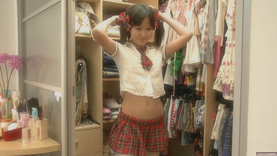 Petite Asian sweetheart putting on her school uniform