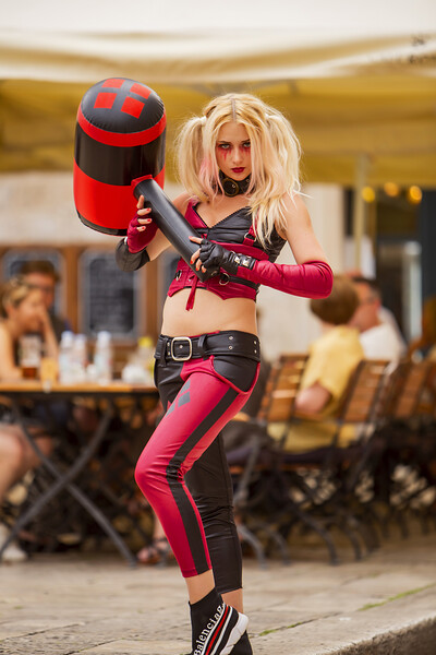 Adventurous blondie attractively poses through the city while wearing Harley Quinn costume