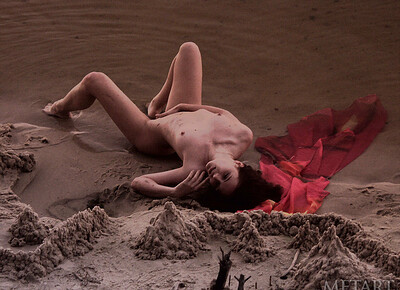 Candid photos of a teen who lies in the sand naked