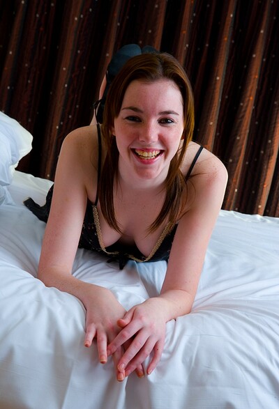 Lindsay enjoys rolling around in bed with a dildo up her snatch