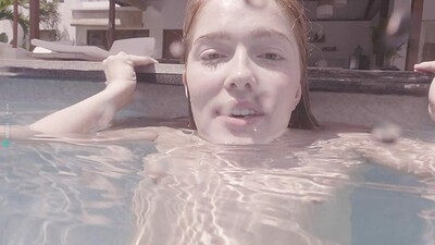 Alluring redhead takes a swim inside her pool and in the process showcases her cute all natural body