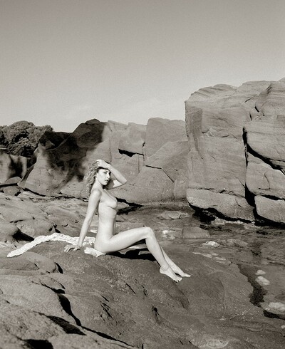 A rocky backgorund makes for the perfect view of her delicate beauty