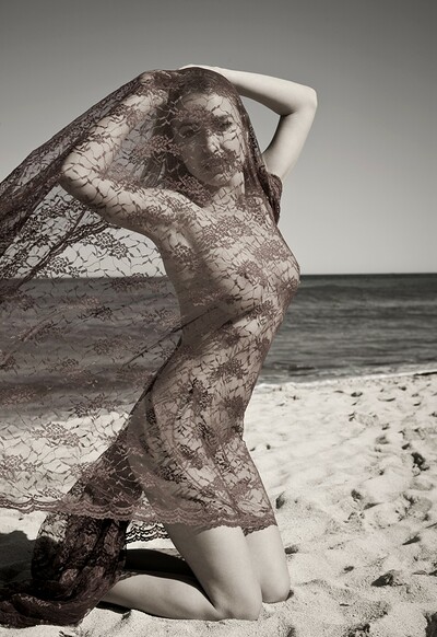 A veil gently caresses Lia May as she dances on the beach