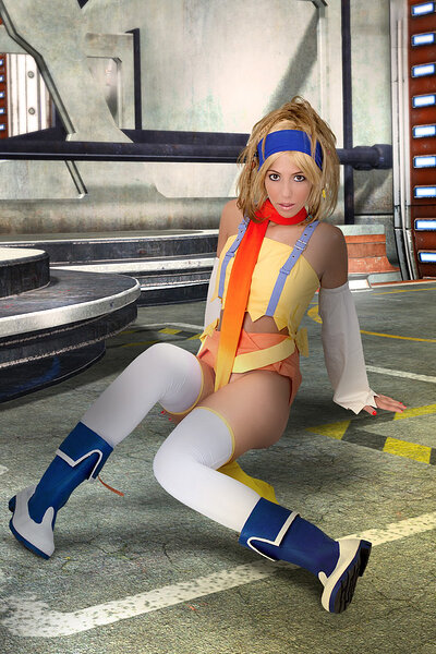 Attractive Shelly vivaciously posing as a Rikku from the Final Fantasy series as she denudes herself