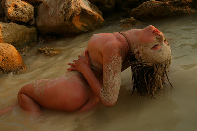 All natural babe goes outdoors and playfully poses in the sand after getting her body wet