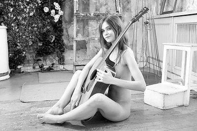 Beautiful brunette chick Jana posing with her guitar presenting her amazing slender body with small perky tits