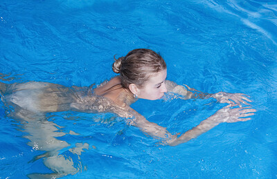 Hawt babe shows off her nips while diving into a pool, soaking her furry pussy.