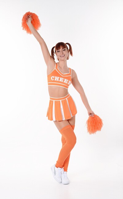 Dolly Dyson, the playful cheerleader, strips off her uniform and plugs a dildo inside her wet pussy.