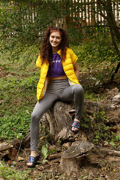 The teen's leggings and T-shirt cling to her curves as she lifts her shirt, exposing her bare breasts to the open air.