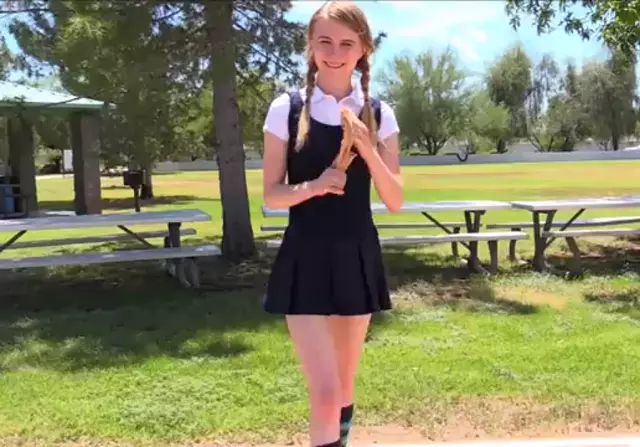 Skinny girl lifting her skirt in a park