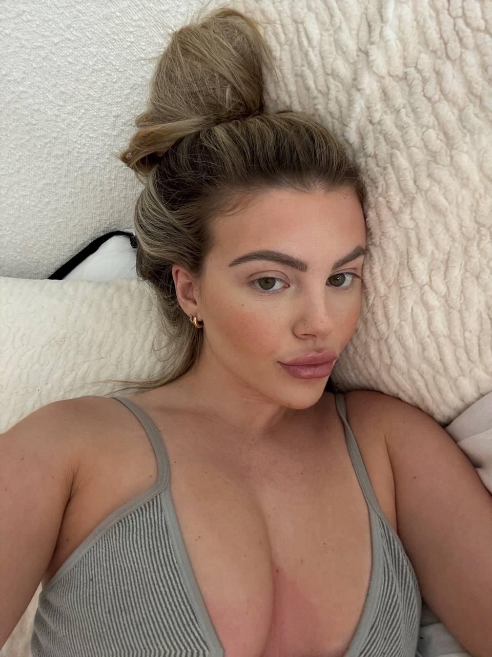 Tilly Harrington's large breasts pressing against her ribbed tank top, teasing with her sultry, inviting gaze.