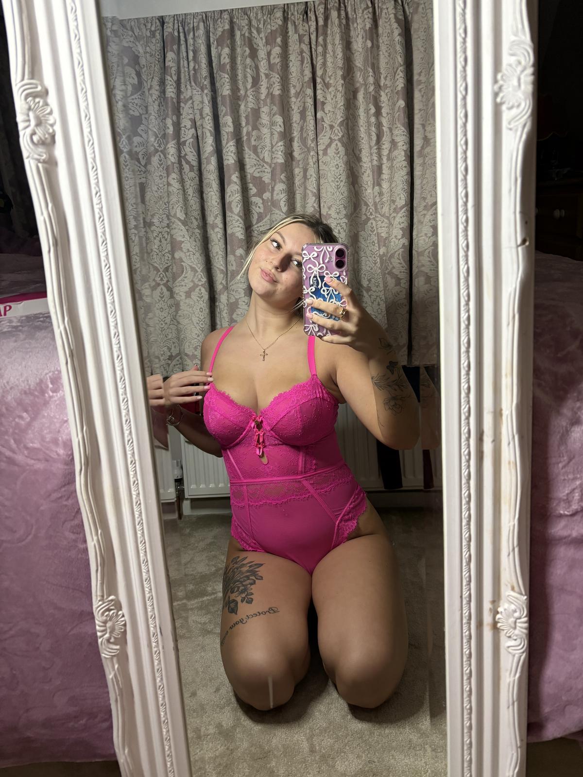 Sofia Bae kneels, her hands on her pink lace lingerie, her tattooed thigh aching with anticipation.