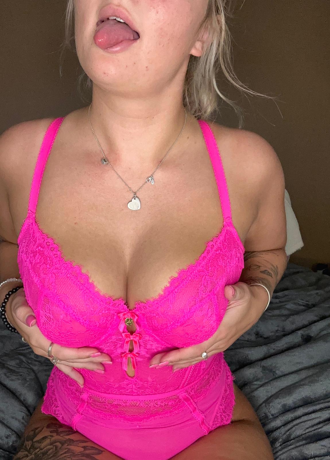 Sofia Bae's tongue teasing, hands squeezing her hot pink lace bra, nipples hard, anticipation building.