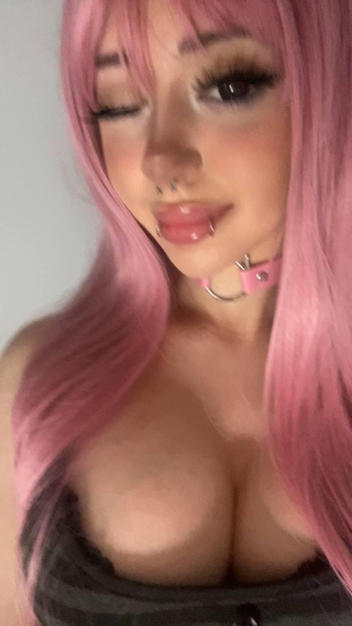 Mimi's plump lips are parted, her pink hair cascading as she teases with her cleavage, feeling so sexy.