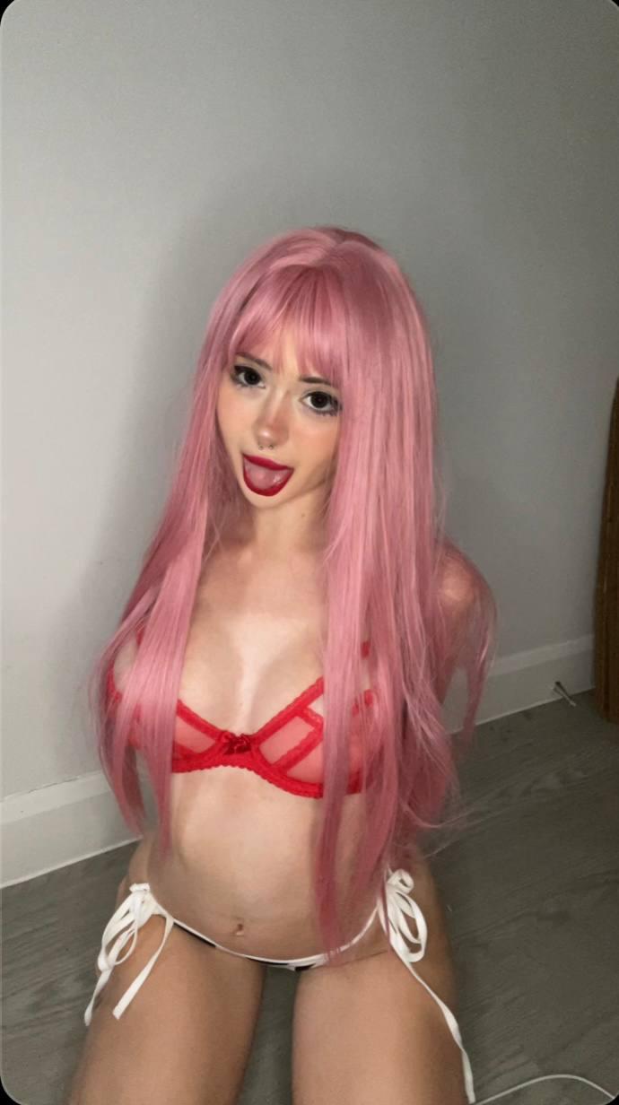 Mimi's pink hair frames her face as she kneels, wearing a red bra and white thong, her lips parted.