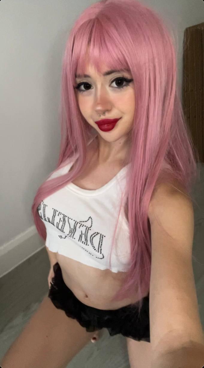 Mimi's pink hair and red lips tease, her white crop top barely covers her eager, exposed breasts.
