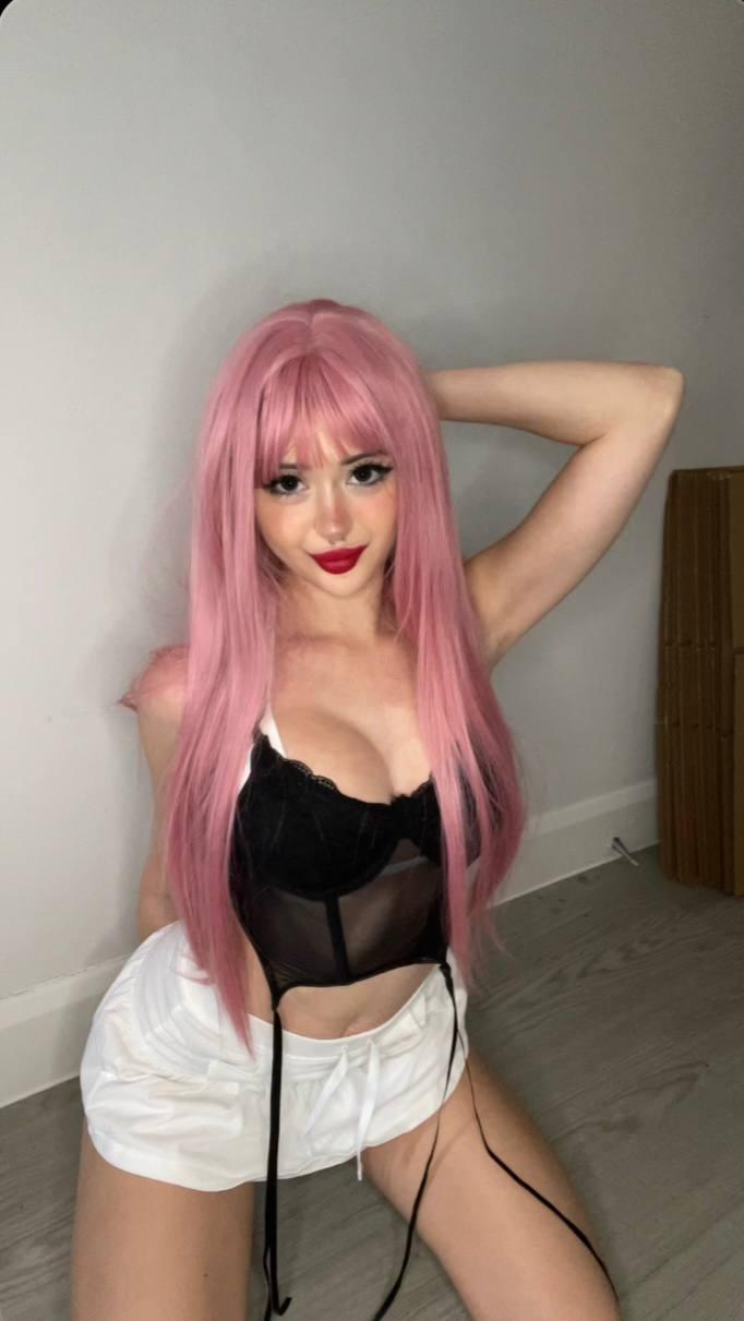 Mimi's pink hair frames her cleavage, her hand behind her head, her white shorts teasing her wet, eager pussy.
