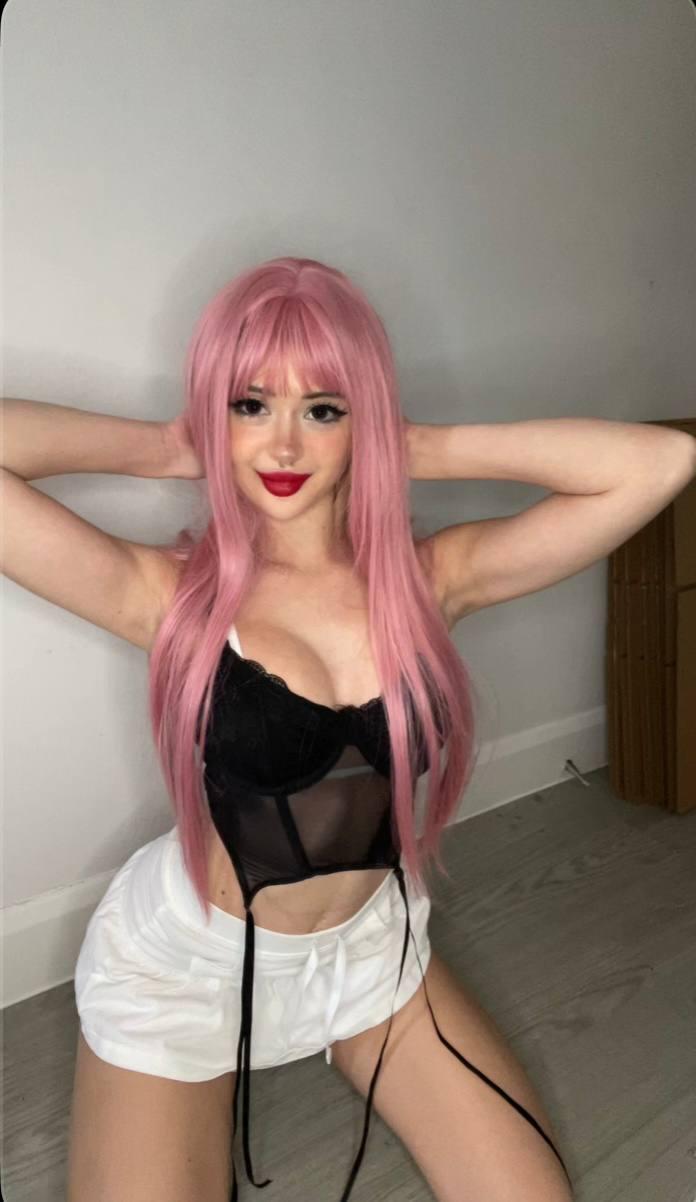 Mimi's pink hair, black lace top, and white shorts, hands behind her head, her cleavage teasingly exposed.
