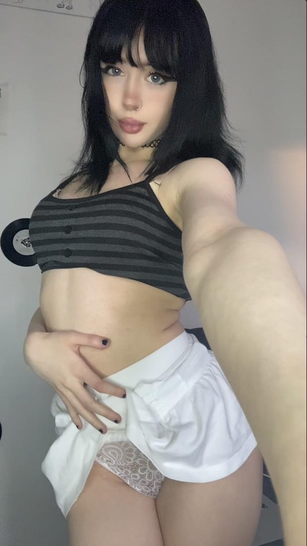 Mimi's white lace panties are teasing, her hand on her skirt, her striped top barely covering her.