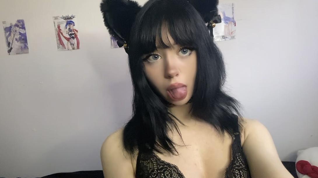 Mimi's tongue teasingly out, black cat ears, lace bra, her wet lips glistening with anticipation.