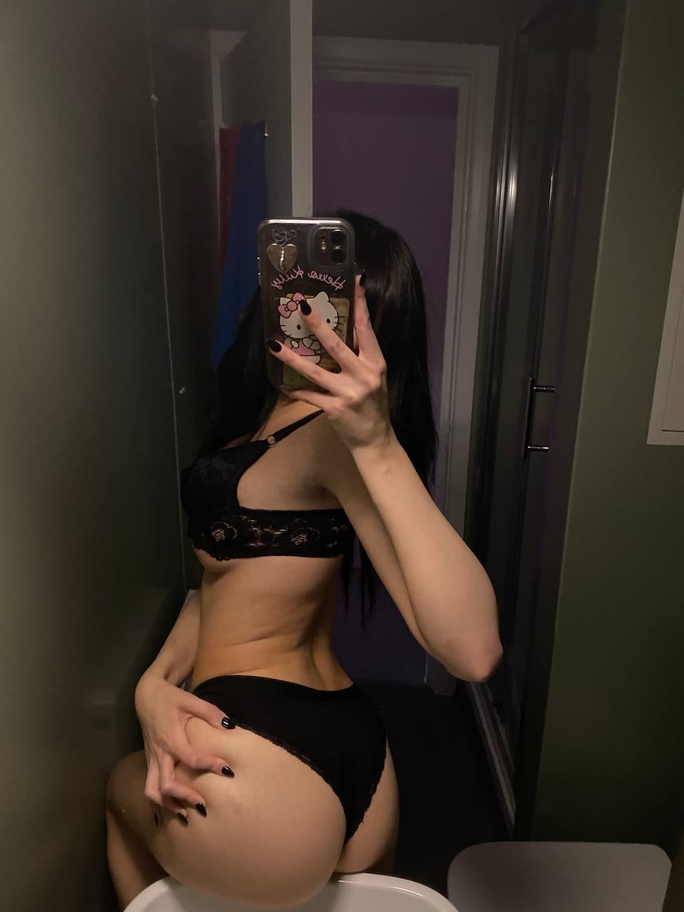 Mimi's curvy ass is teasing, wearing black lace, her hand gripping it, phone in front, mirror shot.