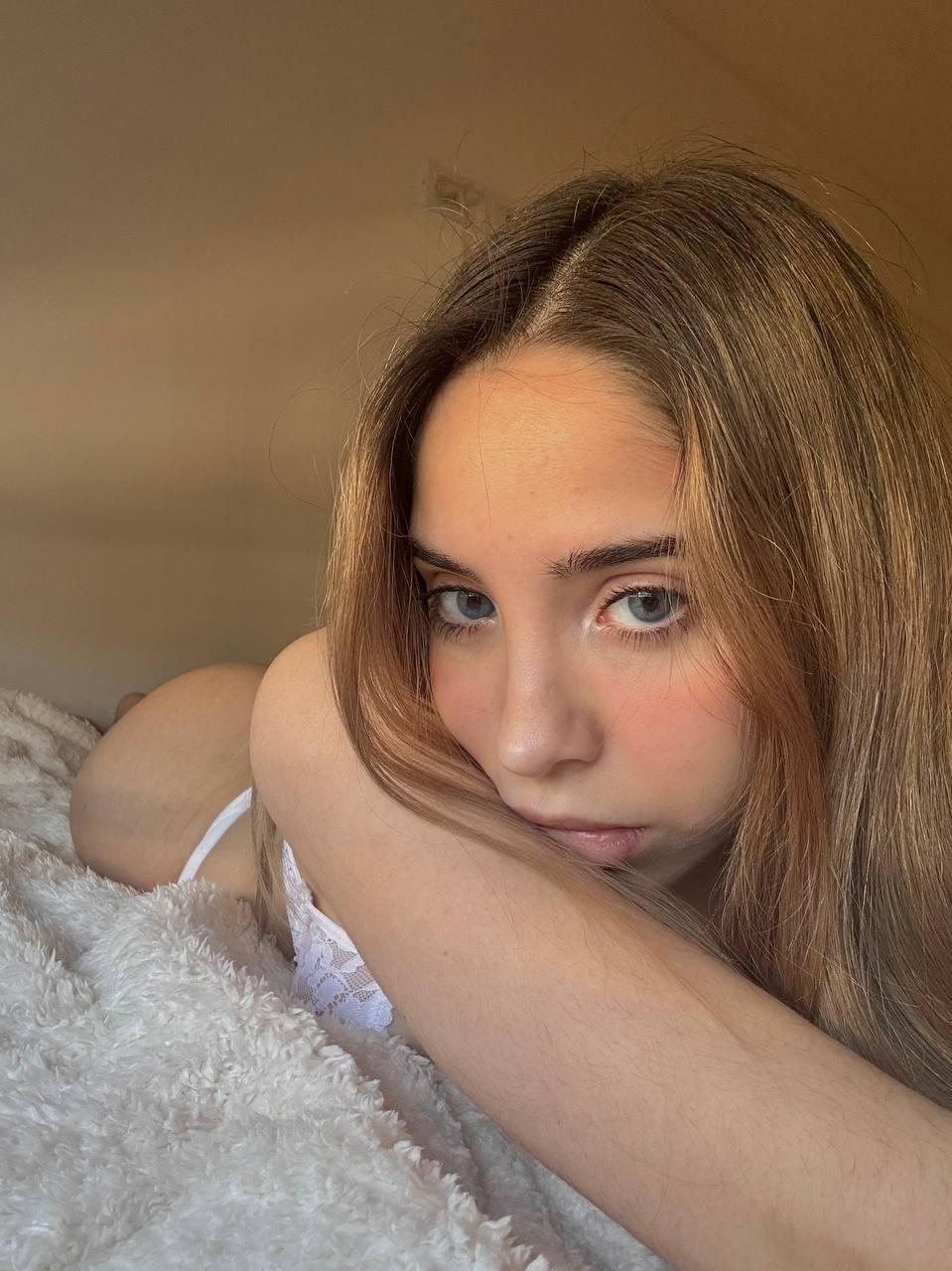 Ella's eyes are locked on you, her lips slightly parted, her ass raised, and her skin glowing softly.