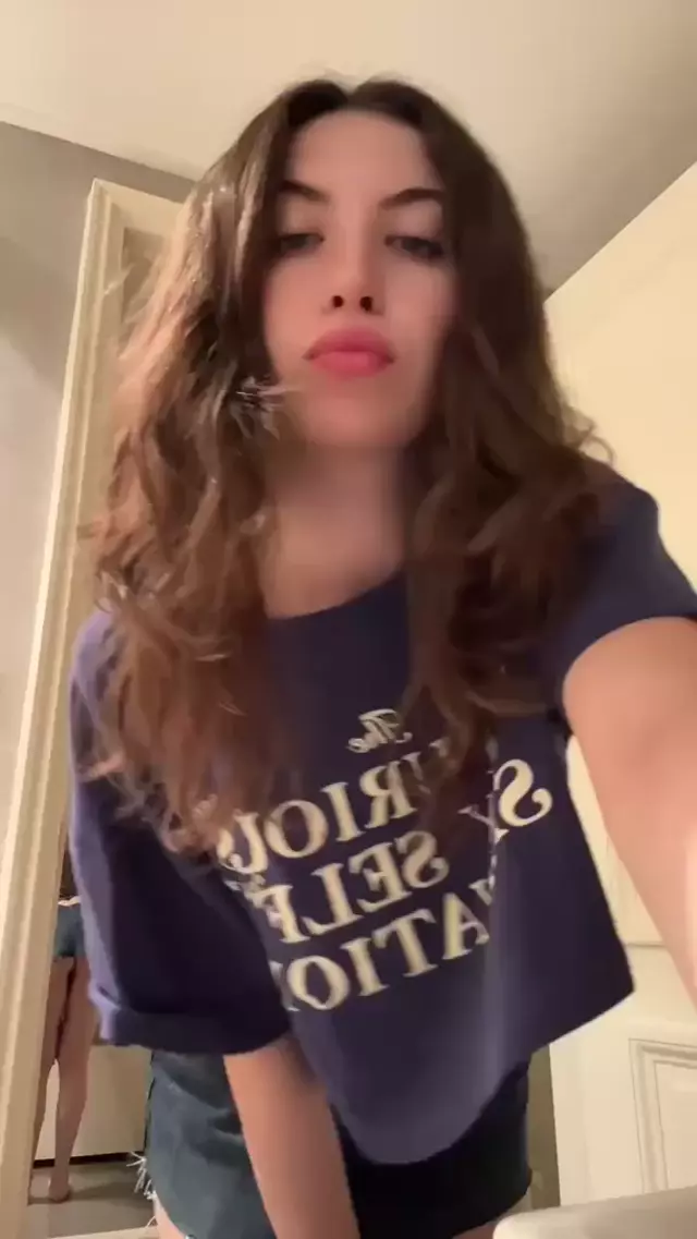 Amber James's flat stomach teasing, wearing jeans, her hand on waist, crop top lifted, revealing her midriff.