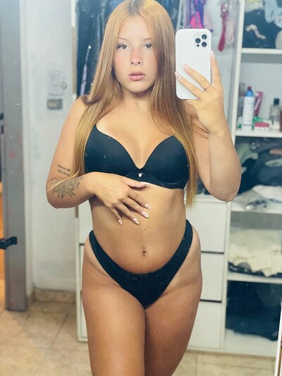 Mia Prescott's hand on her belly, wearing black lingerie, her wet lips slightly parted, anticipating your touch.