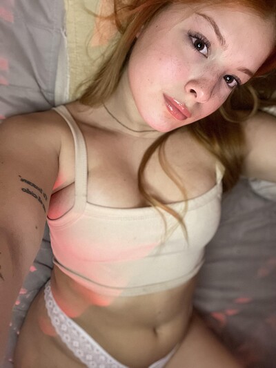 Mia Prescott's wet lips glisten as she lies in white lace panties, her red hair cascading over her chest.