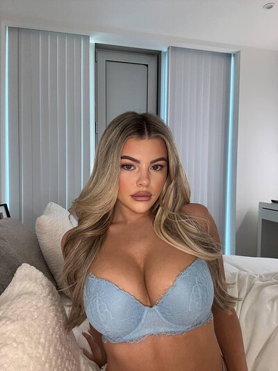 Tilly Harrington's large breasts strain against her lace bra, teasing with every subtle movement.