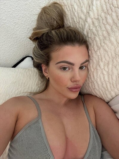 Tilly Harrington's large breasts pressing against her ribbed tank top, teasing with her sultry, inviting gaze.