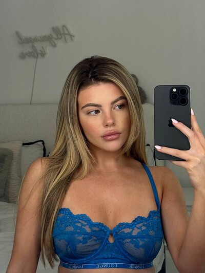 Tilly Harrington's blue lace bra teasingly highlights her cleavage, her lips slightly parted in anticipation.