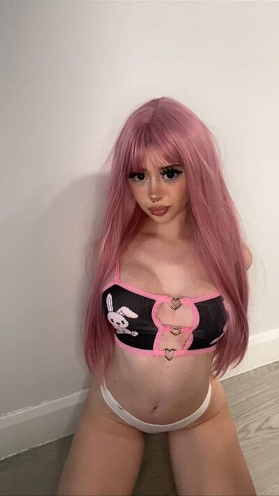 Mimi's pink hair frames her face as she kneels, wearing a sexy bunny-themed top, her nipples barely contained.