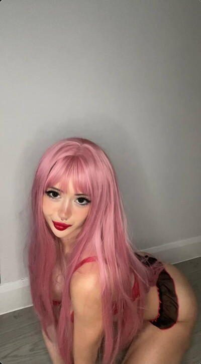 Mimi's pink hair frames her face as she kneels, her red lips parted, anticipating your touch.