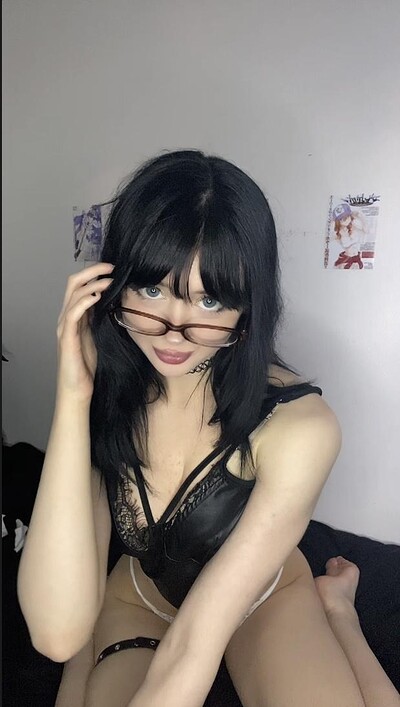 Mimi's black lace lingerie and glasses tease, her pale skin and blue eyes inviting, fingers playing with her frames.