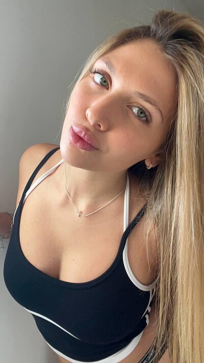 Grace Whitely's large breasts strain against her black sports bra, her green eyes gazing seductively upward.