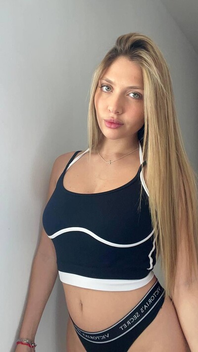 Grace Whitely's long blonde hair cascades over her shoulders, teasing her black sports bra.