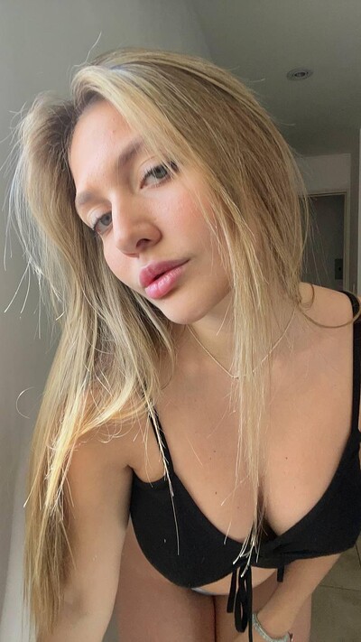 Grace Whitely's lips are slightly parted, her blonde hair cascading, her black bikini top teasing her cleavage.