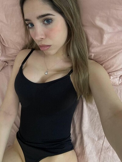 Ella's black tank top hugs her curves, her flushed cheeks hint at her growing arousal.