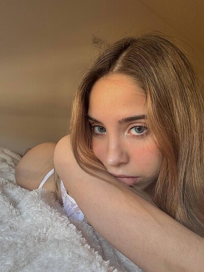 Ella's eyes are locked on you, her lips slightly parted, her ass raised, and her skin glowing softly.