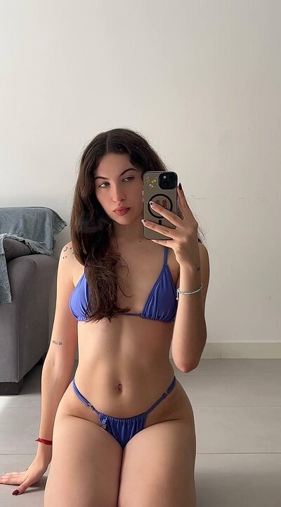 Amber James, in blue bikini, kneels, her wet lips slightly parted, anticipating your touch.